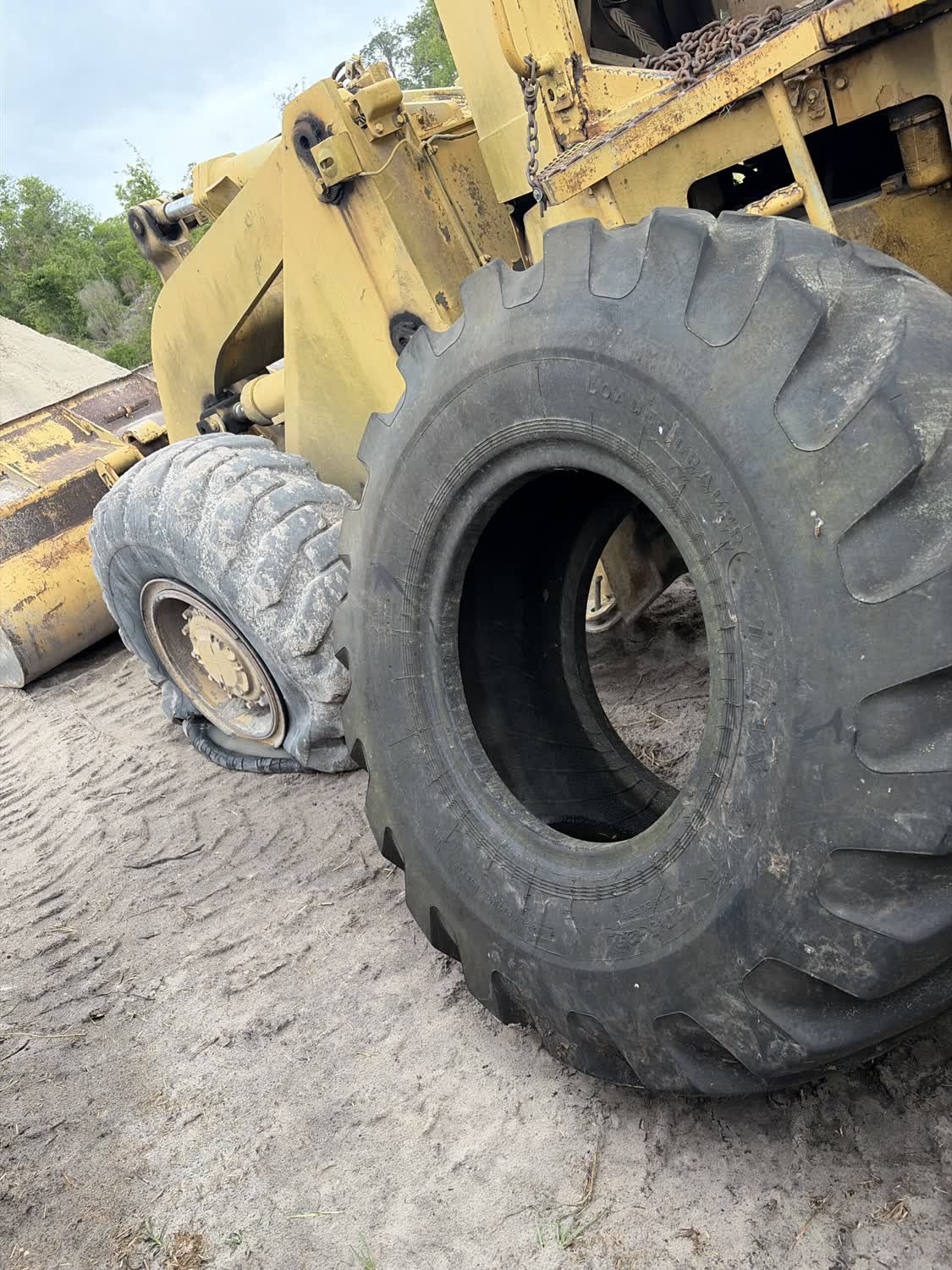 Blown wheel loader tire being replaced with a new OTR tire on site