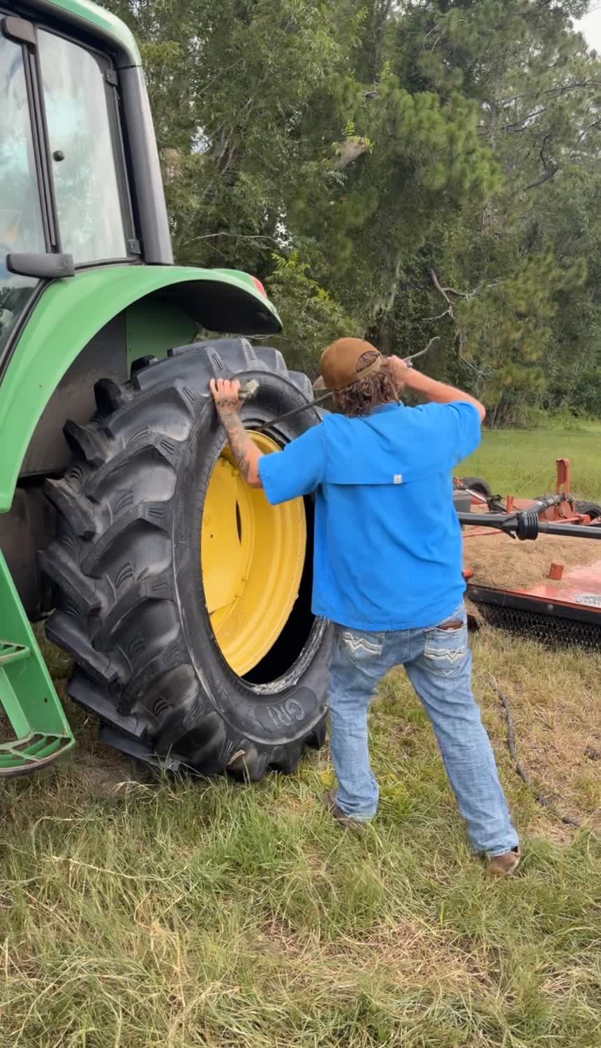 Technician mounting a new rear tractor tire on site