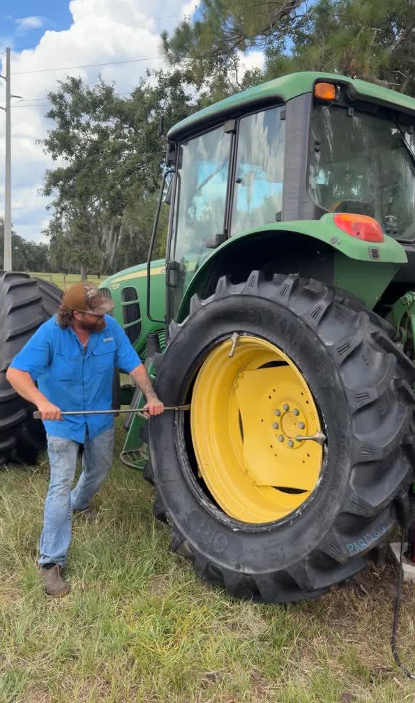 Changing a John Deere tractor tire at a North Florida farm