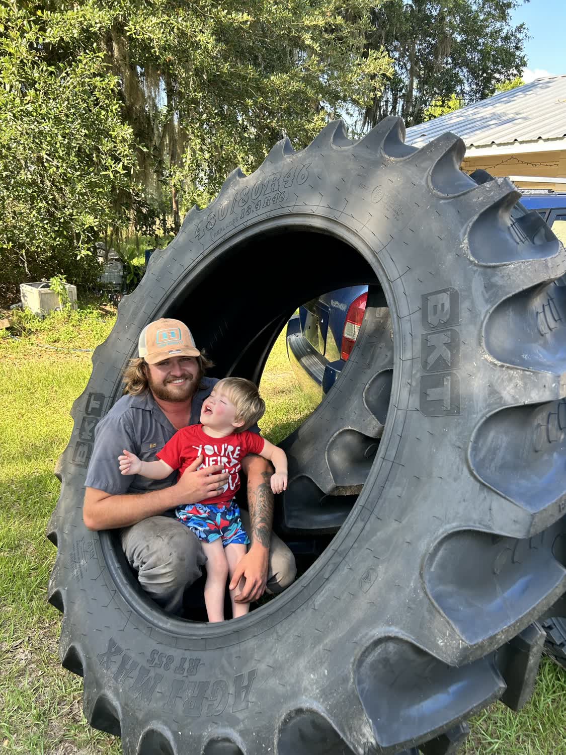 Family-owned - owner and son inside a giant BKT Agri-Max tractor tire